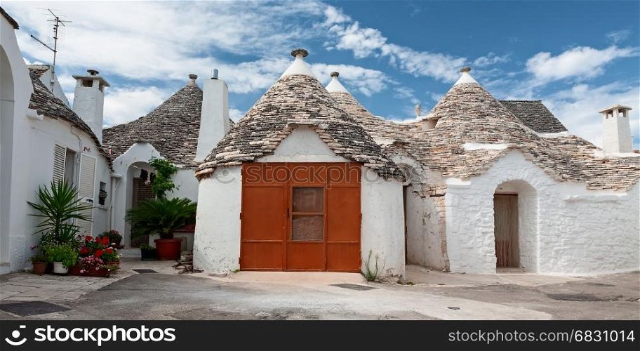 Some Trulli houses in a street of Alberobello in a panoramic view, Puglia, Italy