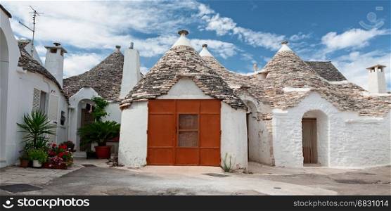 Some Trulli houses in a street of Alberobello in a panoramic view, Puglia, Italy
