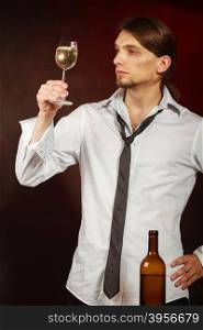 Somellier checking wine quality. . Winery alcohol liquor drinking concept. Somellier checking wine quality. Young male waiter holds wine glass.