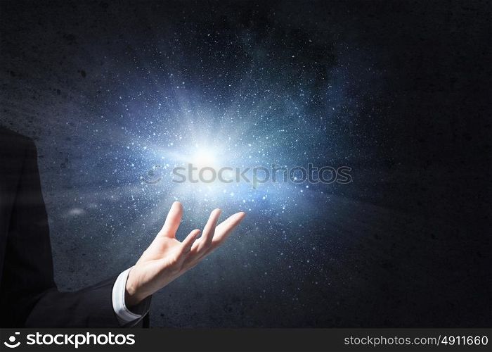 Something magic. Close up of male hand and light glowing in his palm