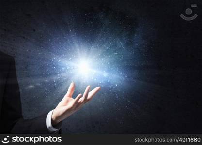 Something magic. Close up of male hand and light glowing in his palm