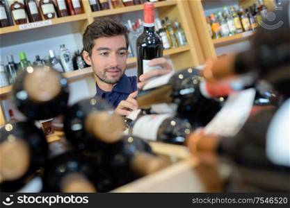 sommelier choosing wine in front of the shelves