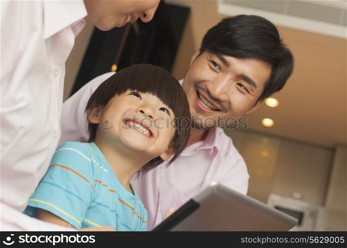 Son and his parents using digital tablet