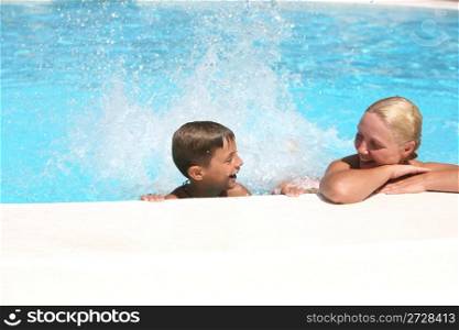 son and mom swim and play in the pool