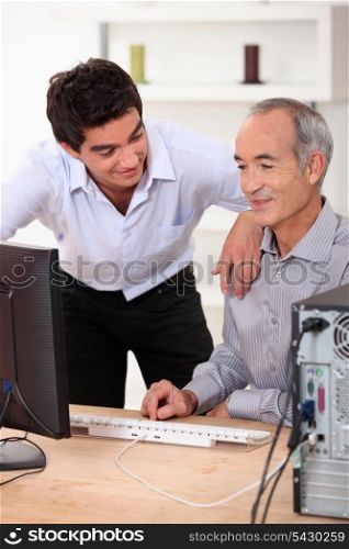 Son helping father with computer