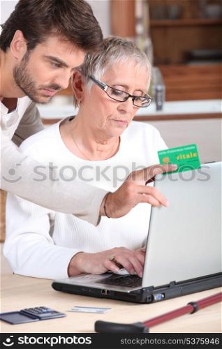 Son helping mother with laptop
