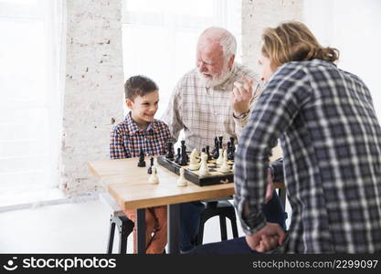 son playing chess with dad