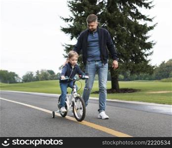 son riding bike park alongside his father