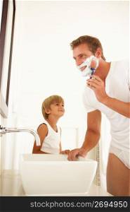 Son Watching Father Shaving In Bathroom Mirror