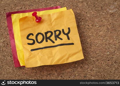 sorry apology - handwriting on a orange sticky note