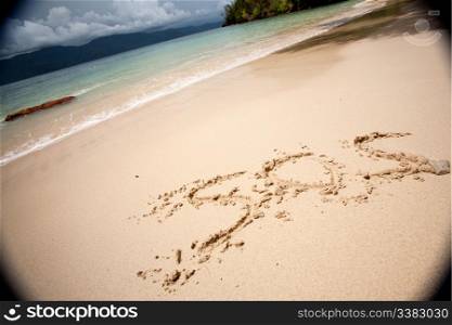 SOS written in the sand with a strong moody vignette