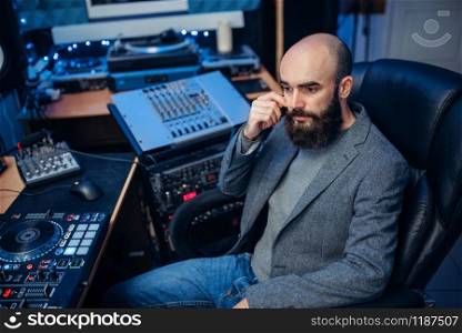 Sound engineer working at the remote control panel in the recording studio. Musician at the mixer, professional audio mixing. Sound engineer working in the recording studio