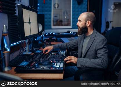 Sound engineer working at the remote control panel in the recording studio. Musician at the mixer, professional audio processing. Sound engineer working in the recording studio