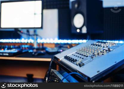 Sound operator and female performer in headphones listens composition in recording studio. Professional audio and music mixing technology. Sound operator and female performer in studio
