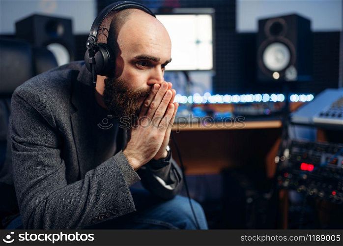 Sound producer listens composition in recording studio. Professional audio and music mixing technology. Sound producer and female singer, recording studio