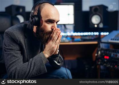 Sound producer listens composition in recording studio. Professional audio and music mixing technology. Sound producer and female singer, recording studio