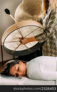 Sound therapy drum. Playing Native American hide drum in sound healing therapy . Sound Therapy Drum