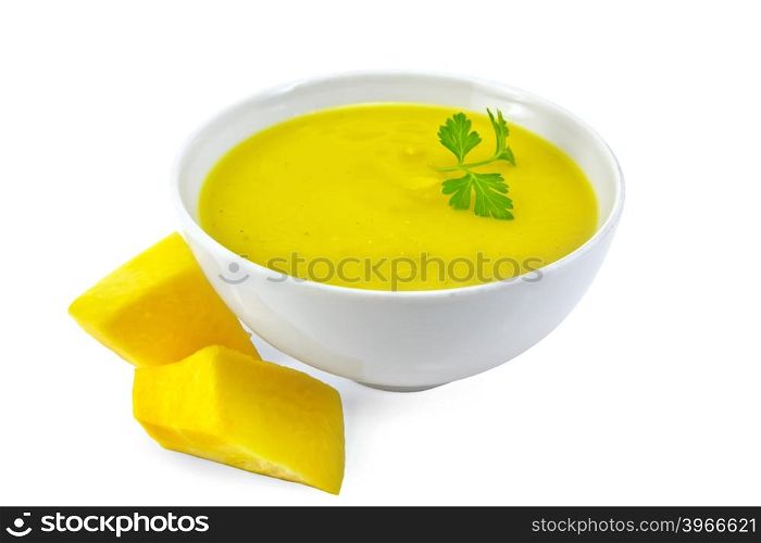Soup-puree pumpkin with parsley in a white bowl, pumpkin slices isolated on white background