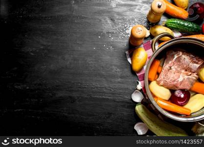 Soup with beef and various vegetables. On a black wooden background. Soup with beef and various vegetables.