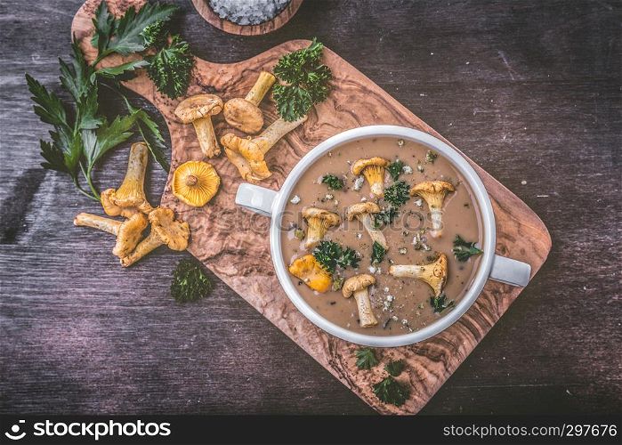Soup with chanterelles and parsley on wood