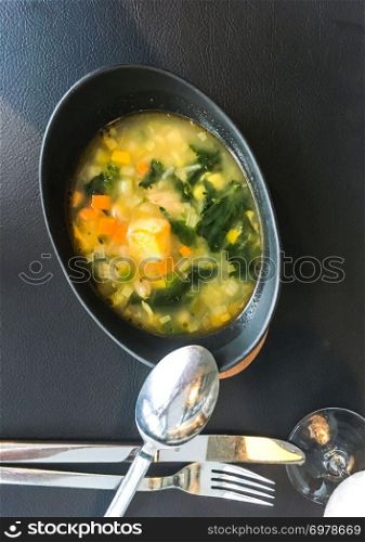 Soup with fresh vegetables on black background. Studio Photo. Soup with fresh vegetables on black background