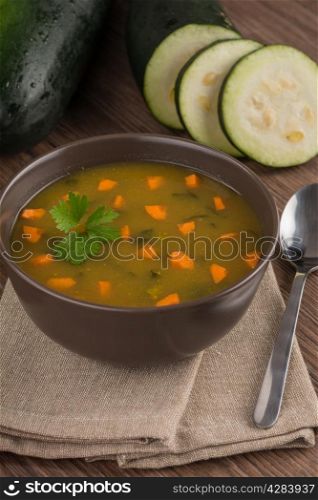 Soup with vegetables on wooden table.