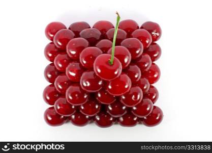 Sour cherries ordered in form of a pyramid top view isolated on white