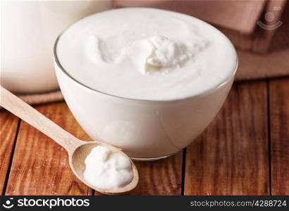 sour cream, yogurt on wooden background