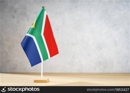 South Africa table flag on white textured wall. Copy space for text, designs or drawings
