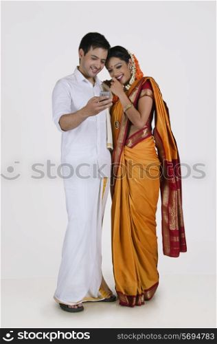 South Indian couple looking at an sms on a mobile phone