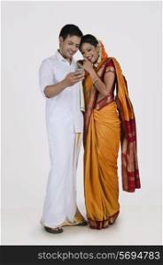 South Indian couple looking at an sms on a mobile phone