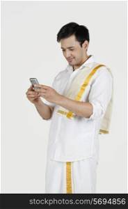 South Indian man reading an sms on a mobile phone