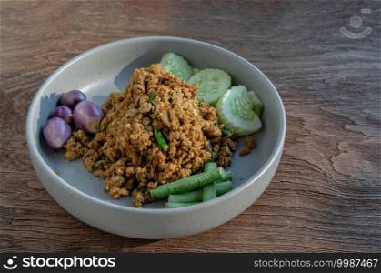 Southern Stir-Fried Pork with Yellow Curry Paste Served with Purple eggplant, Cucumber and Yard long bean. Selective focus.