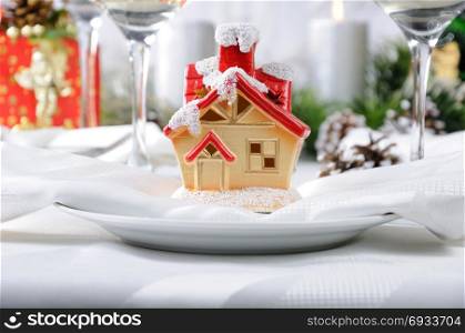 Souvenir in the form of a Christmas house on the Christmas table