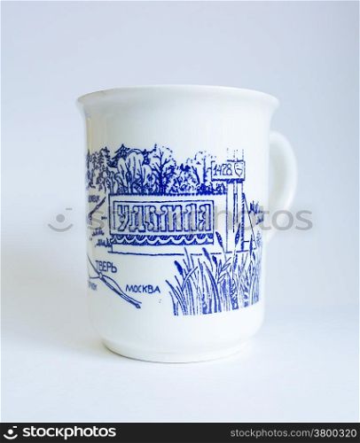Souvenir mug with the inscription in Cyrillic &quot;Udomlya&quot; on a blue background.