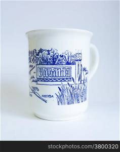 Souvenir mug with the inscription in Cyrillic &quot;Udomlya&quot; on a blue background.