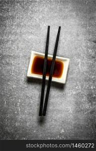 Soy sauce with chopsticks for sushi. On the stone table.. Soy sauce with chopsticks for sushi.