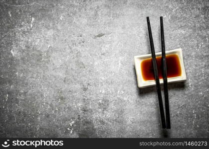 Soy sauce with chopsticks for sushi. On the stone table.. Soy sauce with chopsticks for sushi.