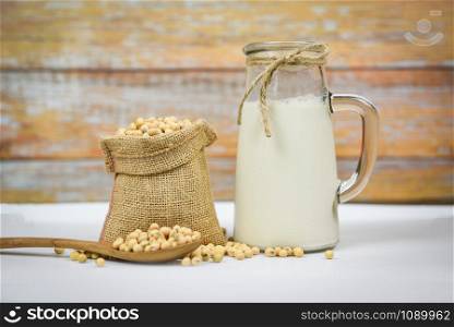 Soybean and dried soy beans on white bowl / Soy milk in glass jar for healthy diet drink and natural bean protein