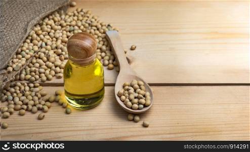Soybean and soybean oil are in a sack bag. Placed on a wooden table