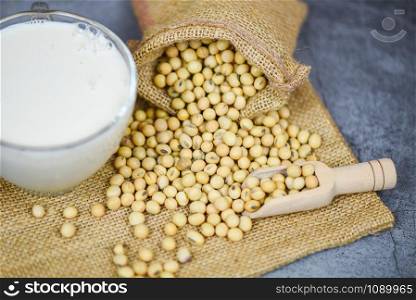 Soybean on sack and soy milk in glass on white gray background / Milk healthy diet and natural bean protein