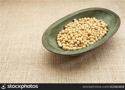 soybeans in a rustic wood bowl against burlap canvas