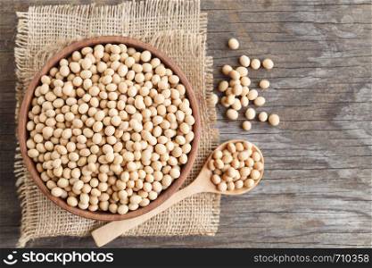 Soybeans in a wooden cup on the old wood table,top view