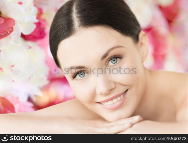 spa and beauty concept - smiling woman in spa salon lying on the massage desk