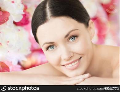 spa and beauty concept - smiling woman in spa salon lying on the massage desk