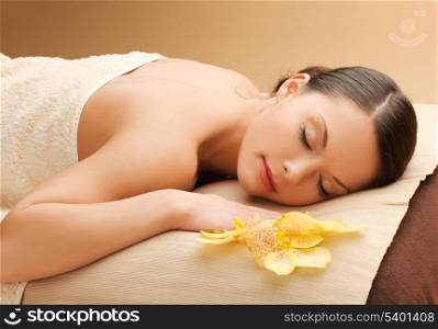 spa and beauty concept - woman in spa salon lying on the massage desk