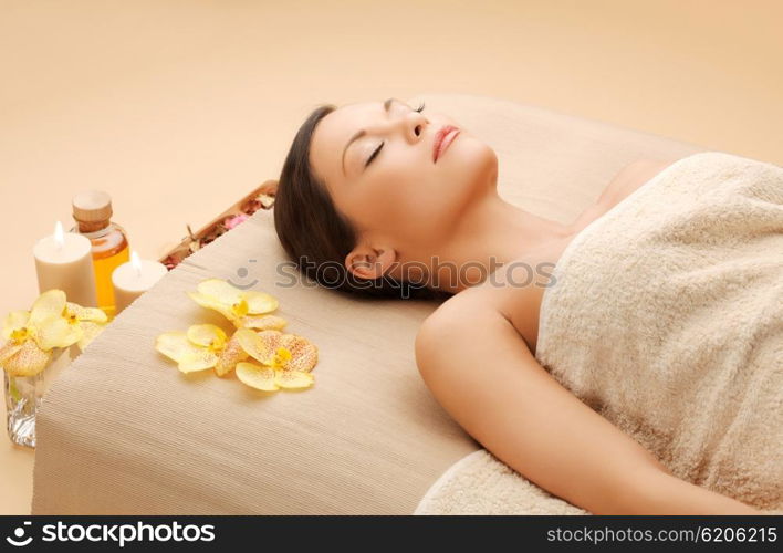 spa and beauty concept - woman in spa salon lying on the massage desk. woman in spa salon