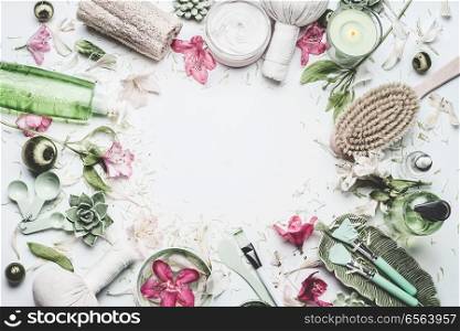 Spa and wellness background with flowers, skin cosmetic products and others body care and massage accessories on white background, top view, frame with copy space