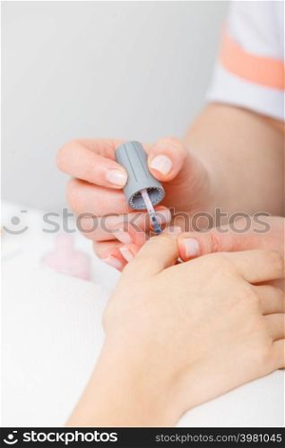 Spa and wellness, beauty concept. Manicurist applying nail polish on woman nails. Manicurist applying nail polish on woman nails