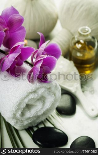 Spa background (white orchid, herbal compress stamps, sea salt, towel and massage stones)